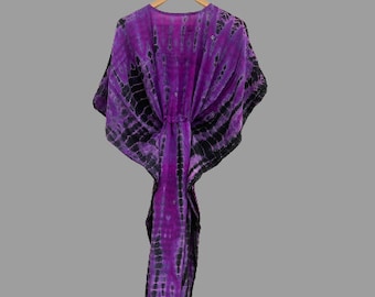 May include: Purple and black tie-dye kaftan with a long, flowing silhouette. The kaftan has a loose, comfortable fit and is perfect for a day at the beach or a casual evening out.