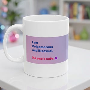 May include: White ceramic mug with a purple and pink gradient band featuring the text "I am Polyamorous and Bisexual. No one's safe." A small devil emoji is at the bottom. The mug has a white handle.