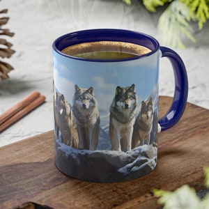 May include: A blue ceramic coffee mug with a wolf pack design. The mug is filled with coffee and steam is rising from the top. The mug is sitting on a wooden cutting board.