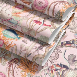 Puede incluir: Papel pintado rosa con una detallada ilustración de vida marina, incluyendo peces, corales y conchas. El diseño tiene un estilo vintage y botánico con un efecto de capas. El papel pintado está enrollado.