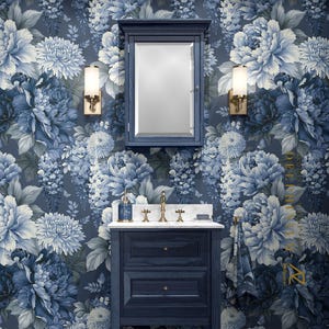 Peut inclure: Un ensemble de meuble-lavabo de salle de bain comprenant un meuble en bois bleu foncé à deux tiroirs, un comptoir en marbre blanc, un robinet en laiton et une armoire à pharmacie assortie avec miroir, encadrée par deux appliques murales en laiton.