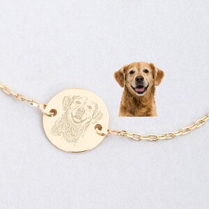 May include: A gold chain necklace with a round pendant featuring a photo of a dog. The pendant is engraved with the dog's image.