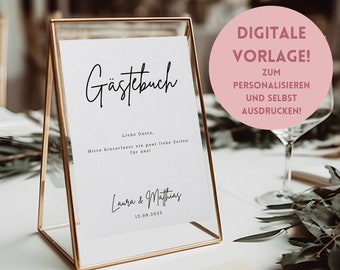 Könnte beinhalten: Ein goldfarbener Rahmen mit einem weißen Hintergrund und schwarzem Text, der "Gästebuch" lautet. Der Text darunter lautet "Liebe Gäste, Bitte hinterlasst ein paar liebe Zeilen für uns!" und "Laura & Matthias 12.09.2023". Ein rosa Kreis mit weißem Text lautet "DIGITALE VORLAGE! ZUM PERSONALISIEREN UND SELBST AUSDRUCKEN!"