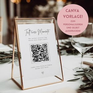 Può includere: Un cartello con cornice dorata con il testo "Teitt cure Momente" e un codice QR. Il cartello include anche il testo "Wir wollen unseren Tag durch eure Augen sehen." e "Ladet eure Fotos & Videos direkt hier hoch." Un cerchio rosa con il testo "CANVA VORLAGE!" sullo sfondo.