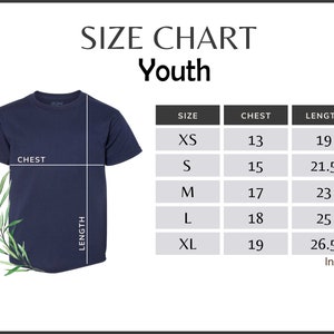 Puede incluir: Camiseta azul marino para j&oacute;venes con una tabla de tallas. La tabla enumera las medidas de pecho y largo en pulgadas para las tallas XS a XL. La camiseta se muestra con indicadores de pecho y largo.