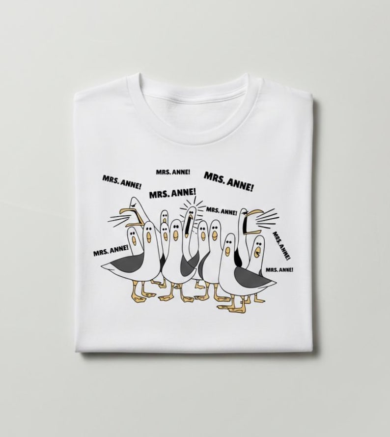 May include: White t-shirt featuring a cartoon illustration of seagulls with the text "MRS. ANNE!" in speech bubbles. The seagulls are in various poses, with black and white feathers and yellow feet.