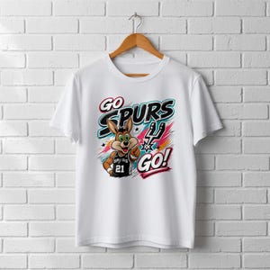 Op de afbeelding: Wit T-shirt met een cartoon konijn met een basketbalshirt met nummer 21. Het shirt toont "GO SPURS GO!" in een kleurrijk ontwerp, ideaal voor fans van de San Antonio Spurs.