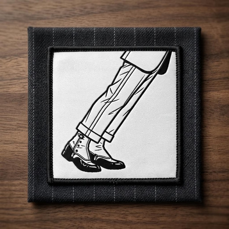 May include: Black and white illustration of a person's legs and feet in a classic pose, wearing dress pants and shoes. The image is on a square, dark gray fabric coaster with a pinstripe pattern.