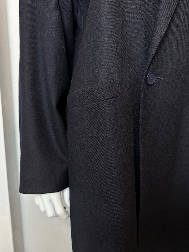 May include: A black long-sleeved blazer with a single button closure and a pocket on the left side.