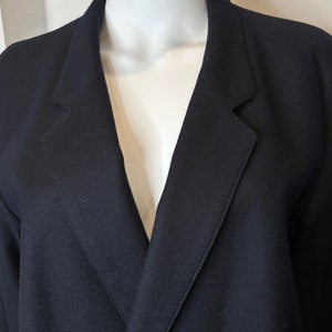 May include: A black blazer with a deep V-neck and a single button closure.