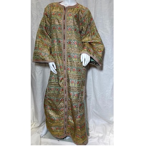 May include: A floor-length kaftan featuring a metallic gold base with horizontal bands of intricate floral embroidery in red, green, and blue. The garment has long, wide sleeves, a round neckline, and a central vertical trim with decorative beadwork.