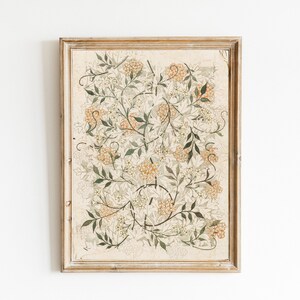 May include: A framed print of a botanical illustration featuring a delicate floral design with intricate details. The artwork features a light beige background with a pattern of green leaves and small white flowers, accented with clusters of orange-yellow flowers.