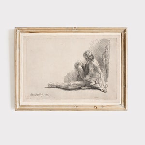 K&ouml;nnte beinhalten: Eine Schwarzwei&szlig;-Radierung einer sitzenden nackten Figur, gerahmt in einem hellen Holzrahmen. Die Radierung tr&auml;gt den Titel "Rembrandt f. 1646."