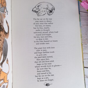 Op de afbeelding: Pagina van een open boek met een vintage illustratie van een slapende kat, vergezeld van een gedicht. De tekst "CAT" staat boven de illustratie en het gedicht beschrijft een kat.