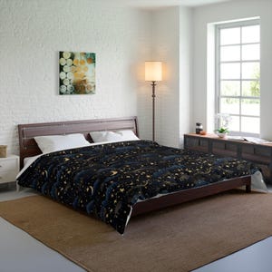 May include: A dark comforter with a celestial design featuring gold stars, crescent moons, and stylized clouds on a black background. The bedding is on a wooden bed frame in a bedroom setting.