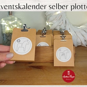 May include: Kraft paper Advent calendar tags with metal clips, featuring white circular designs with a horse illustration and numbers. The tags are displayed in a wooden box, with a decorative bottle and wreath in the background.