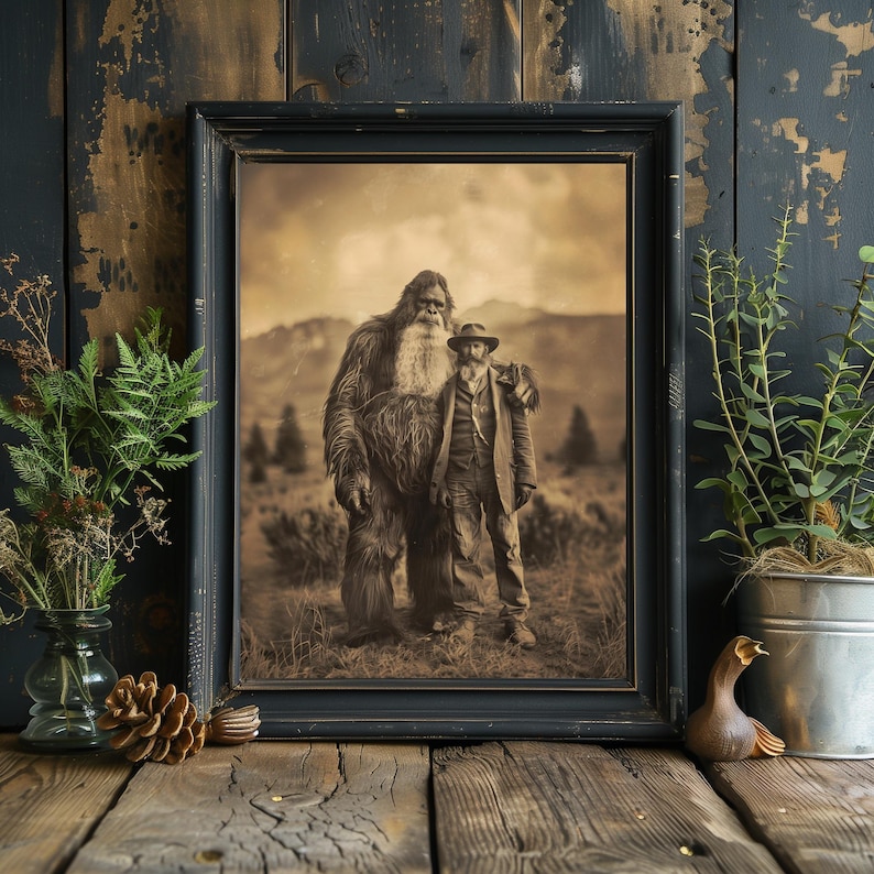 Puede incluir: Una fotograf&iacute;a en sepia de un gran Bigfoot peludo de pie junto a un hombre en un entorno boscoso. El Bigfoot tiene una expresi&oacute;n amigable y una larga barba. El hombre lleva un sombrero y una chaqueta. La fotograf&iacute;a est&aacute; enmarcada en un marco negro.