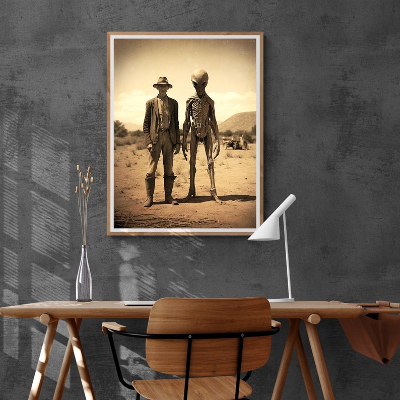 May include: A sepia-toned photograph of a man in a hat standing next to a tall, grey alien. The man is wearing a long-sleeved shirt and pants. The alien has a long, thin body and a large head. They are both standing in a desert landscape.