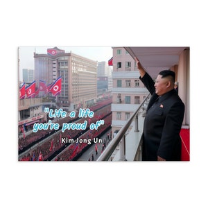 Könnte beinhalten: Ein Mann in einem schwarzen Anzug steht auf einem Balkon und winkt einer Menschenmenge zu, die sich unten befindet. Das Zitat "Lebe ein Leben, auf das du stolz bist" - Kim Jong Un ist auf dem Bild zu sehen.