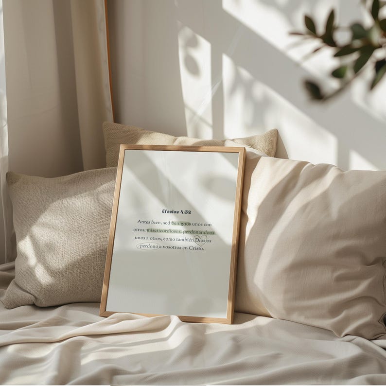 K&ouml;nnte beinhalten: Ein gerahmter Druck mit Text in einem hellen Holzrahmen. Der Druck ist an Kissen und einer Decke angelehnt. Der Text ist in Schwarz und Gr&uuml;n. Der Hintergrund ist in neutralen T&ouml;nen gehalten.