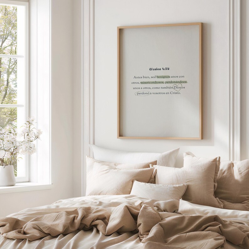 K&ouml;nnte beinhalten: Ein gerahmter Druck mit spanischem Text in einem Schlafzimmer. Der Text hat einen hellgr&uuml;nen Akzent. Der Rahmen ist aus hellem Holz und die Bettw&auml;sche ist beige. Ein Fenster mit wei&szlig;en Blumen ist sichtbar.