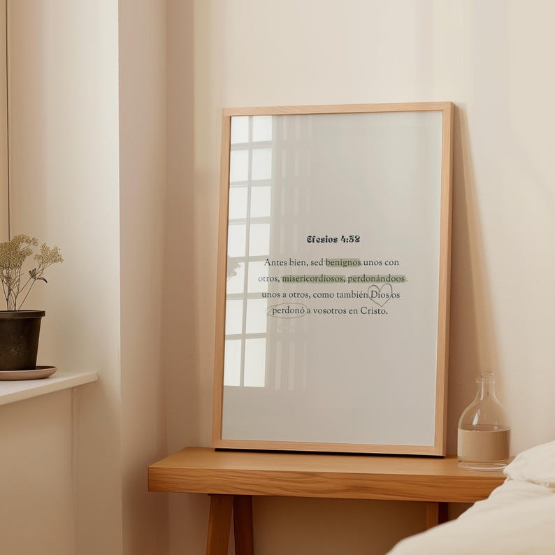 K&ouml;nnte beinhalten: Ein gerahmter Druck mit einem hellen Holzrahmen. Der Druck zeigt Text auf Spanisch, mit den Worten "Efesios 4:32" oben. Der Text ist in einer schwarzen, eleganten Schrift auf einem neutralen Hintergrund. Der Druck wird auf einem Holztisch pr&auml;sentiert.