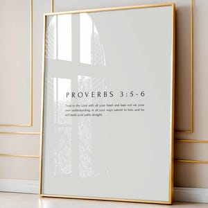 Könnte beinhalten: Ein rechteckiger Wandkunstdruck in einem dünnen goldenen Rahmen mit dem Text Proverbs 3:5-6. Der Druck zeigt die Schriftstelle: Trust in the Lord with all your heart and lean not on your own understanding; in all your ways submit to him.