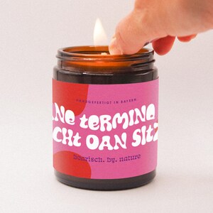 Vela con el lema bávaro "SIN DÁTILES Y FÁCIL DE LIMPIAR" de color blanco crema, 140 g, cera de colza vegana, de Múnich.