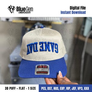 May include: A baseball cap with a white crown and a blue brim. The text "GAME DAY" is embroidered in blue across the front. The cap has a "Blue Gem Embroidery" logo and the words "Digital File Instant Download".