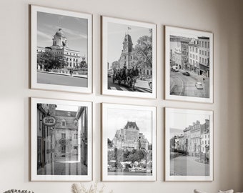 May include: A living room interior with a white couch, a coffee table, and a white ottoman. The walls are decorated with black and white framed photographs of cityscapes.