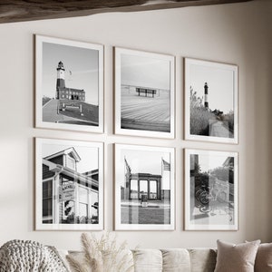 Peut inclure: Six photographies encadrées en noir et blanc de scènes côtières, dont des phares et des promenades, sont accrochées au mur. L'ensemble est disposé dans un salon avec un canapé beige, une table basse ronde et une fenêtre.