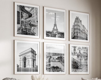 May include: A living room interior with a white couch and a coffee table. Six black and white framed photographs of Parisian landmarks are displayed on the wall. The photographs include the Eiffel Tower, the Arc de Triomphe, and a street scene.