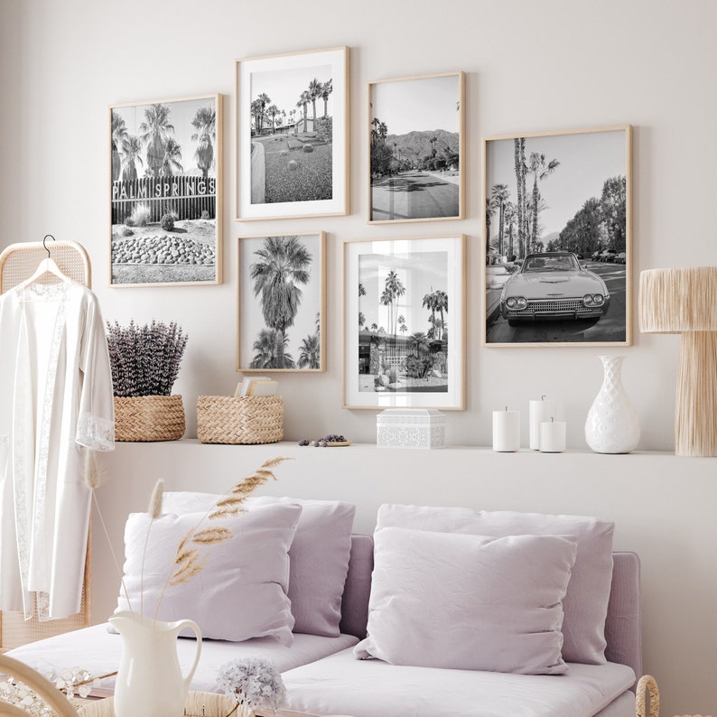 Może przedstawiać: Czarno-białe fotografie palm, zabytkowego samochodu i znaku z napisem "Palm Springs". Zdjęcia są oprawione i wiszą na białej ścianie nad jasnofioletową kanapą.