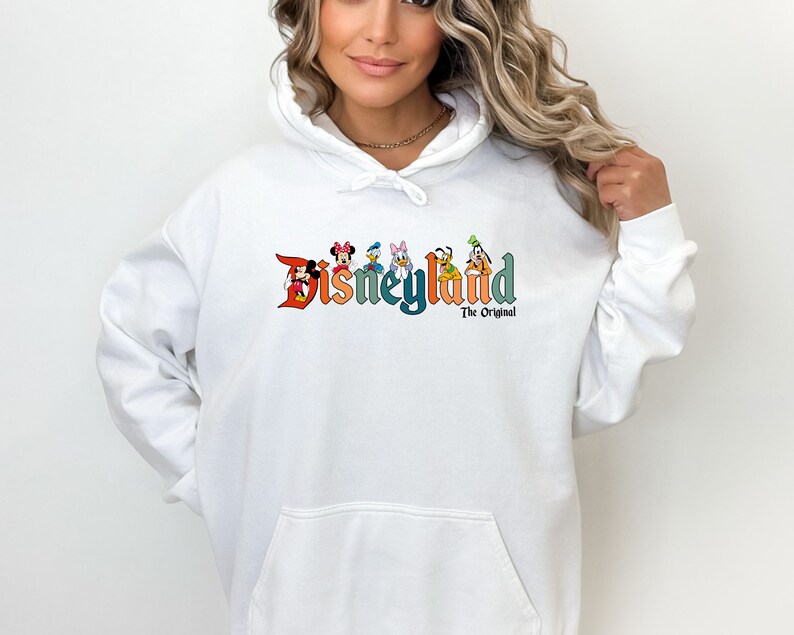 Puede incluir: Sudadera con capucha blanca con un logotipo de Disneyland colorido que presenta a Mickey Mouse, Minnie Mouse, Donald Duck, Goofy y Pluto. El texto debajo del logotipo dice "The Original."
