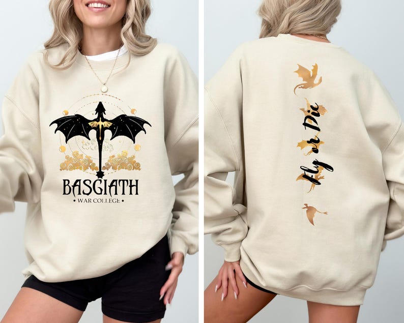 May include: A beige sweatshirt with a black dragon graphic on the front and the text "BASGIATH - WAR COLLEGE" below. The back of the sweatshirt has a gold dragon graphic and the text "Fly or Die".