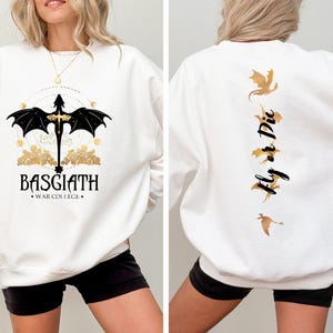 May include: White sweatshirt with a black dragon graphic on the front and the text "BASGIATH. WAR COLLEGE."  The back of the sweatshirt has the text "Fly or Die" with a gold dragon graphic.