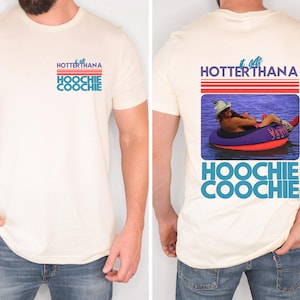 May include: Cream-colored t-shirt with the text "HOTTERTHANA HOOCHIE COOCHIE" in blue and red. The back of the shirt features a graphic of a person in a tube on the water, with the same text.