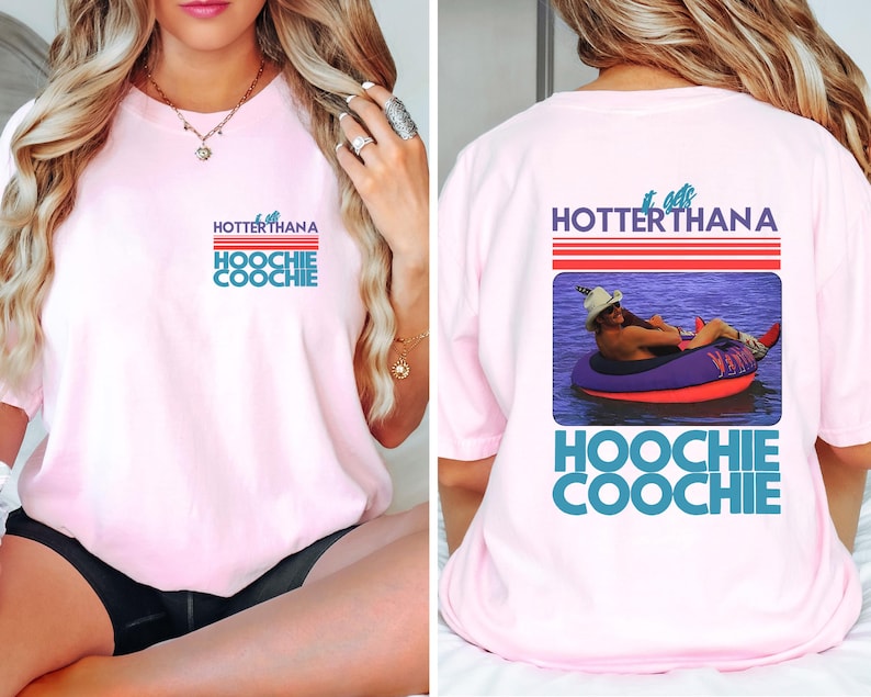 May include: Light pink t-shirt with the text "Hotter Than a Hoochie Coochie" in red, white, and blue. The back of the shirt features a graphic of a person in a tube on the water with the same text.