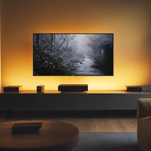 Könnte beinhalten: Ein modernes Wohnzimmer mit einem großen Flachbildfernseher, der eine Naturszene zeigt. Der Fernseher ist an einer Wand mit warmer Umgebungsbeleuchtung montiert. Ein niedriger Schrank beherbergt Audiogeräte. Ein runder Couchtisch und ein Sofa vervollständigen die Szene.