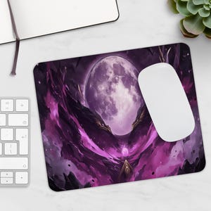 Könnte beinhalten: Rechteckiges Mauspad mit einer Fantasy-Landschaft. Es zeigt einen großen, leuchtenden lila Mond, dunkelviolette und rosa Wolken sowie Felsformationen. Eine weiße Computermaus ist ebenfalls vorhanden.