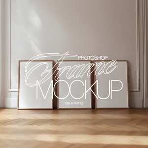 May include: Three wooden picture frames with white mounts on a light wood floor. The frames are empty and ready for your photos or artwork. The text "Frame Mockup" is written in white on the wall behind the frames.