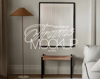 May include: A black picture frame mockup with a 4x5 ratio, hanging on a white wall. The frame is in a living room setting with a floor lamp and a bench.
