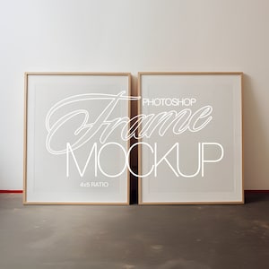 May include: Two rectangular picture frames with light wood frames are leaning against a white wall. The frames have a white background with the words "Photoshop Frame Mockup" in a cursive font. The ratio is 4x5.