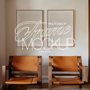 May include: Two brown leather chairs with wooden frames sit in front of a white wall with two empty picture frames. The frames are brown wood with a white mat. The text "PHOTOSHOP FRAME MOCKUP DIN A RATIO" is written in white on the wall.