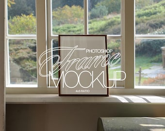 May include: A brown wooden frame with a white mount and a white background. The frame is sitting on a white windowsill. The text "PHOTOSHOP FRAME MOCKUP 4x5 RATIO" is printed on the frame.