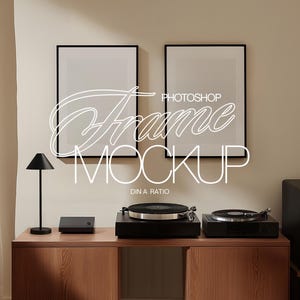 Pode incluir: Interior de um quarto com duas maquetes de arte emolduradas, uma lâmpada preta e duas vitrolas em um armário de madeira. O texto "Photoshop Frame Mockup" está sobreposto.