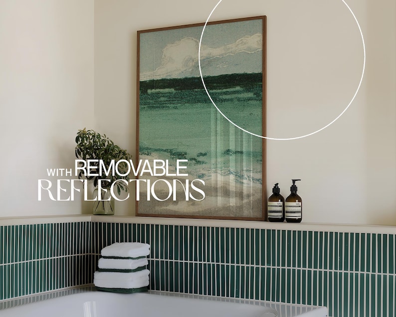 May include: A bathroom with green tile, a white bathtub, and a framed print of a seascape. The print has the text "WITH REMOVABLE REFLECTIONS" on it. There are two bottles of liquid soap on a shelf above the bathtub.
