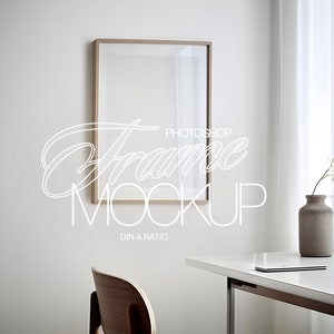 May include: A light wood frame mockup with a white background. The frame is hanging on a white wall. A wooden chair and a white table are in the foreground. The text "Frame Mockup" is written in white on the image.