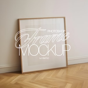 May include: A brown wood frame with a white mat and a white background. The frame is sitting on a light wood floor with a herringbone pattern. The text "Photoshop Frame Mockup 1x1 Ratio" is printed on the white background.
