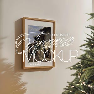 May include: A wooden frame with a picture of a building with a blue sky and white clouds. The frame is on a white wall with a Christmas tree in the background.